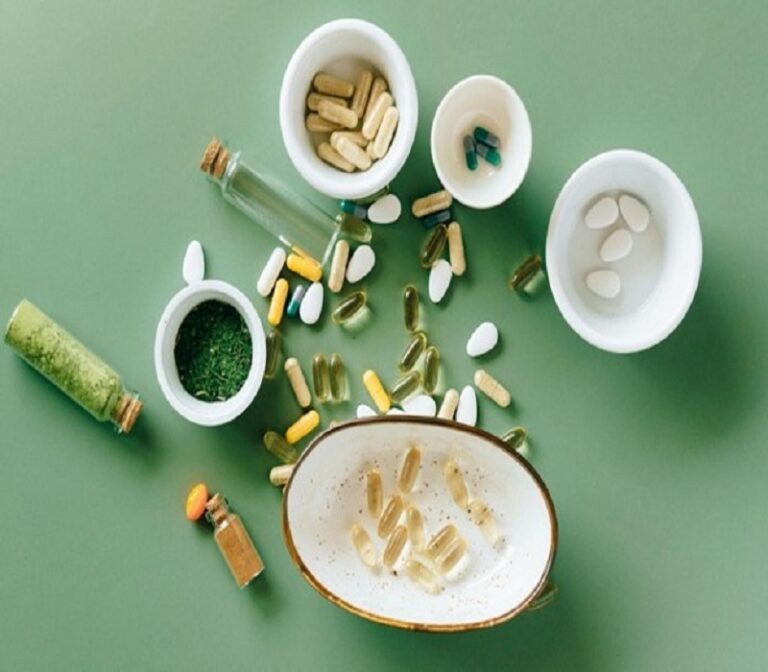 "Various capsules, tablets, and bottles of supplements displayed on a green background."