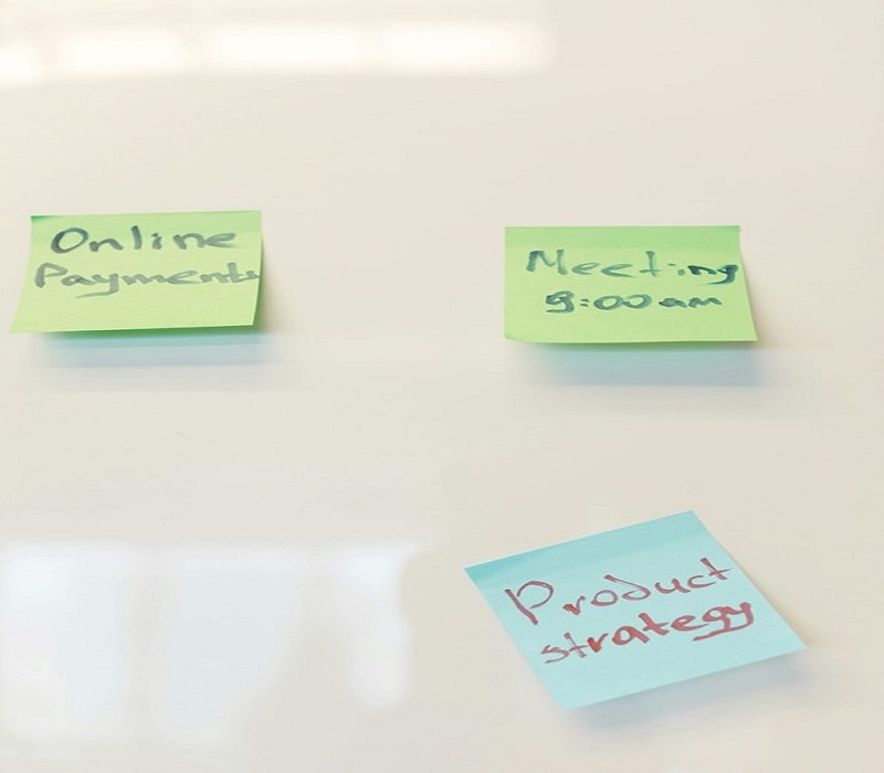 Sticky notes on a whiteboard labeled 'Online Payments,' 'Meeting 9:00 AM,' and 'Product Strategy.